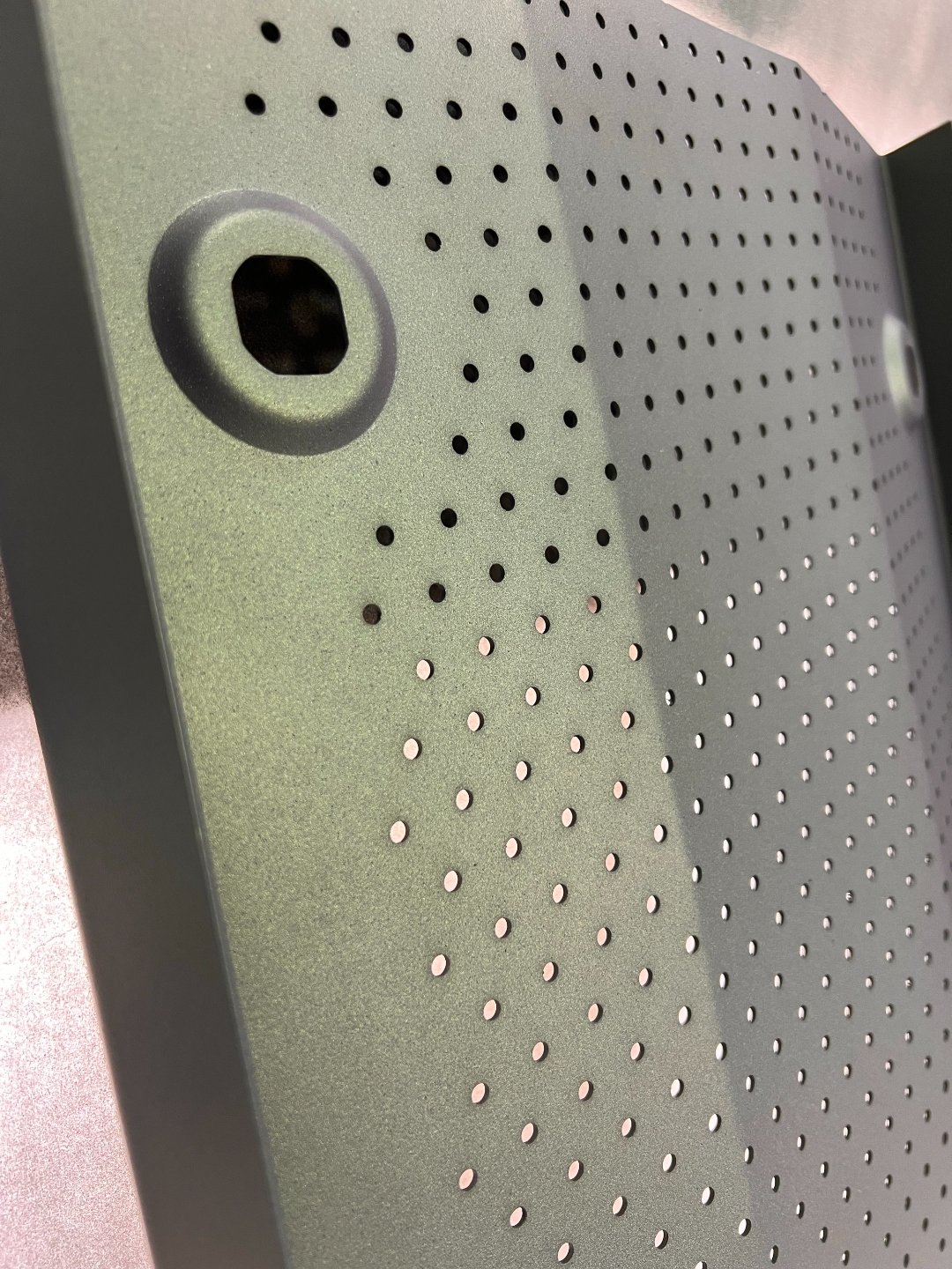 Close up of an AEGIS coated perforated diffuser panel showing clean open steam holes and uniform coverage