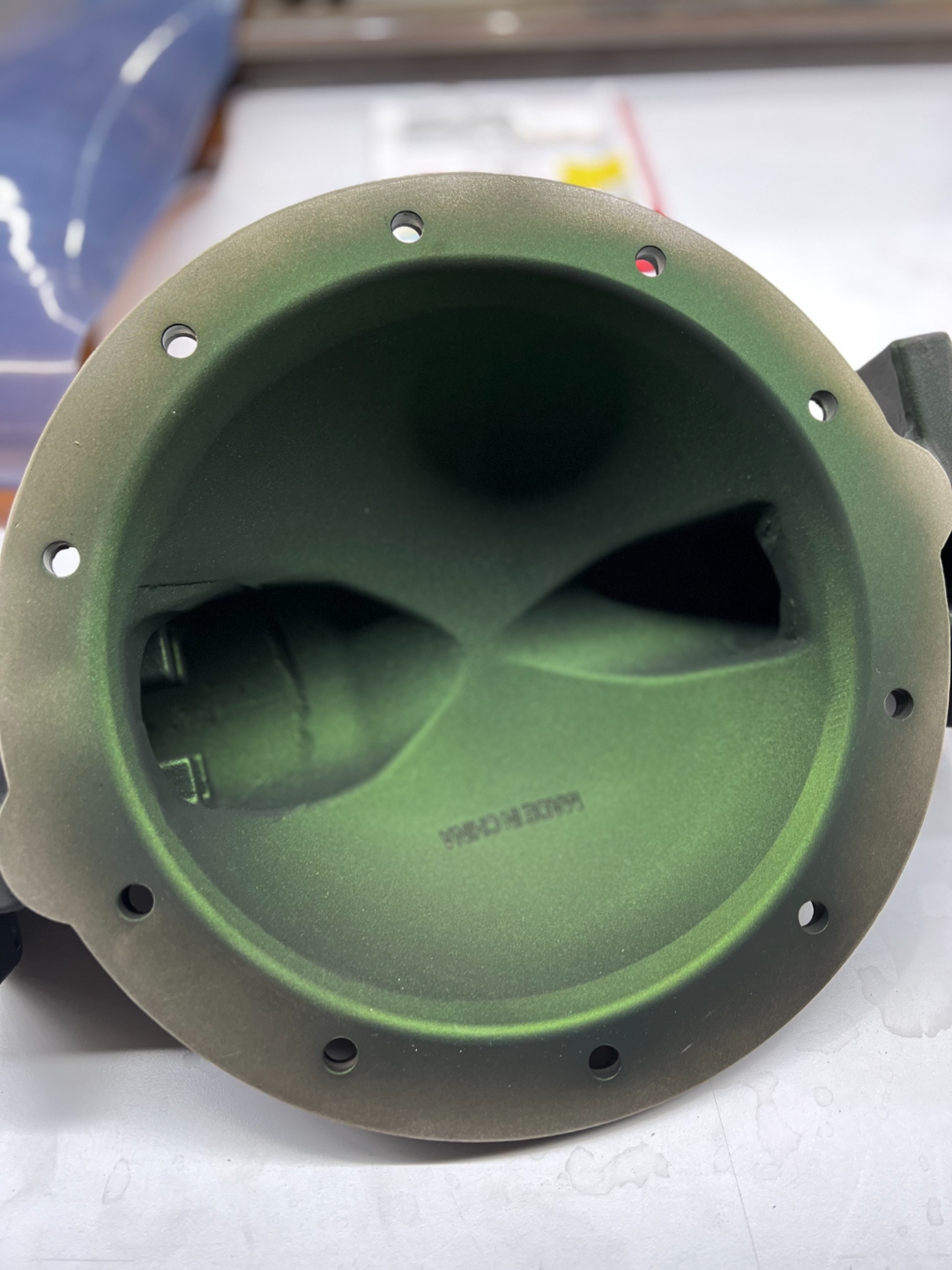 Same aluminum pump housing after AEGIS coating, smooth uniform green corrosion-resistant finish