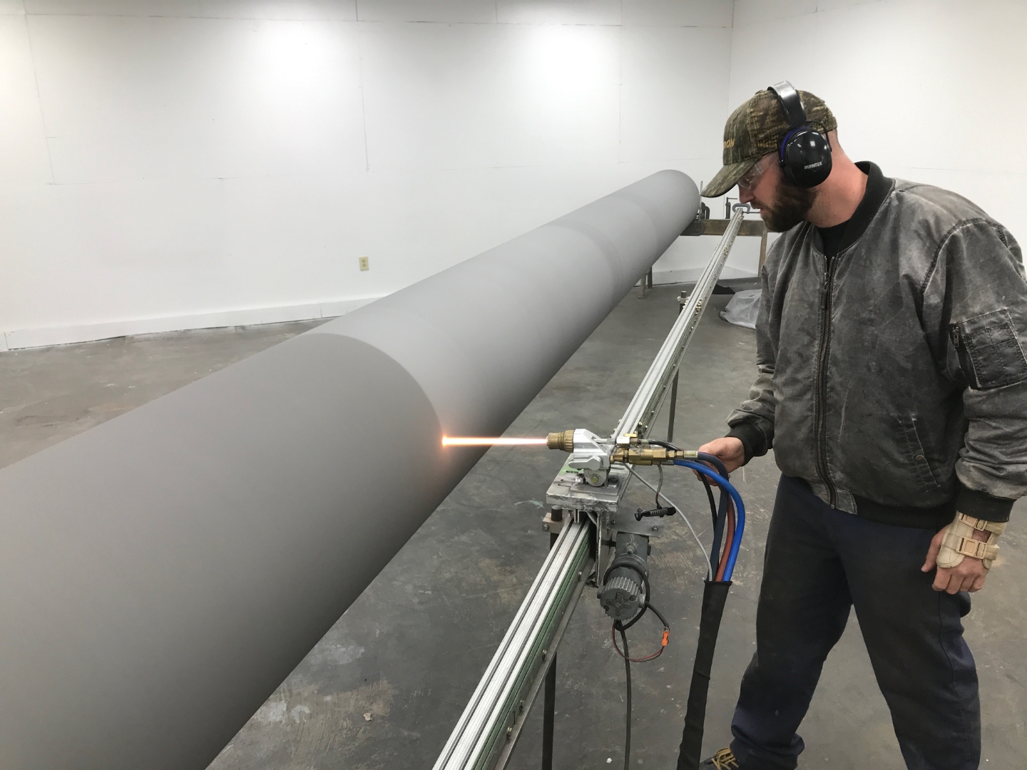AEGIS technician applying thermal spray coating to industrial component